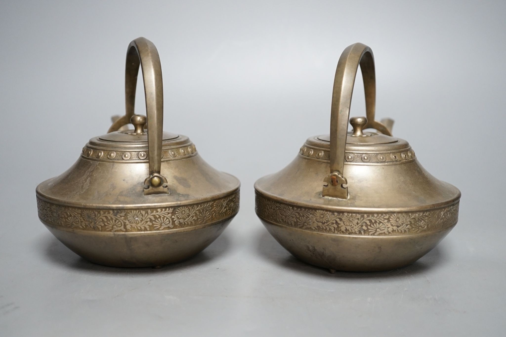 A pair of bronze teapots